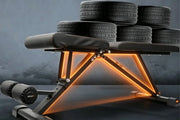 Gym bench with tire weights on a dark background