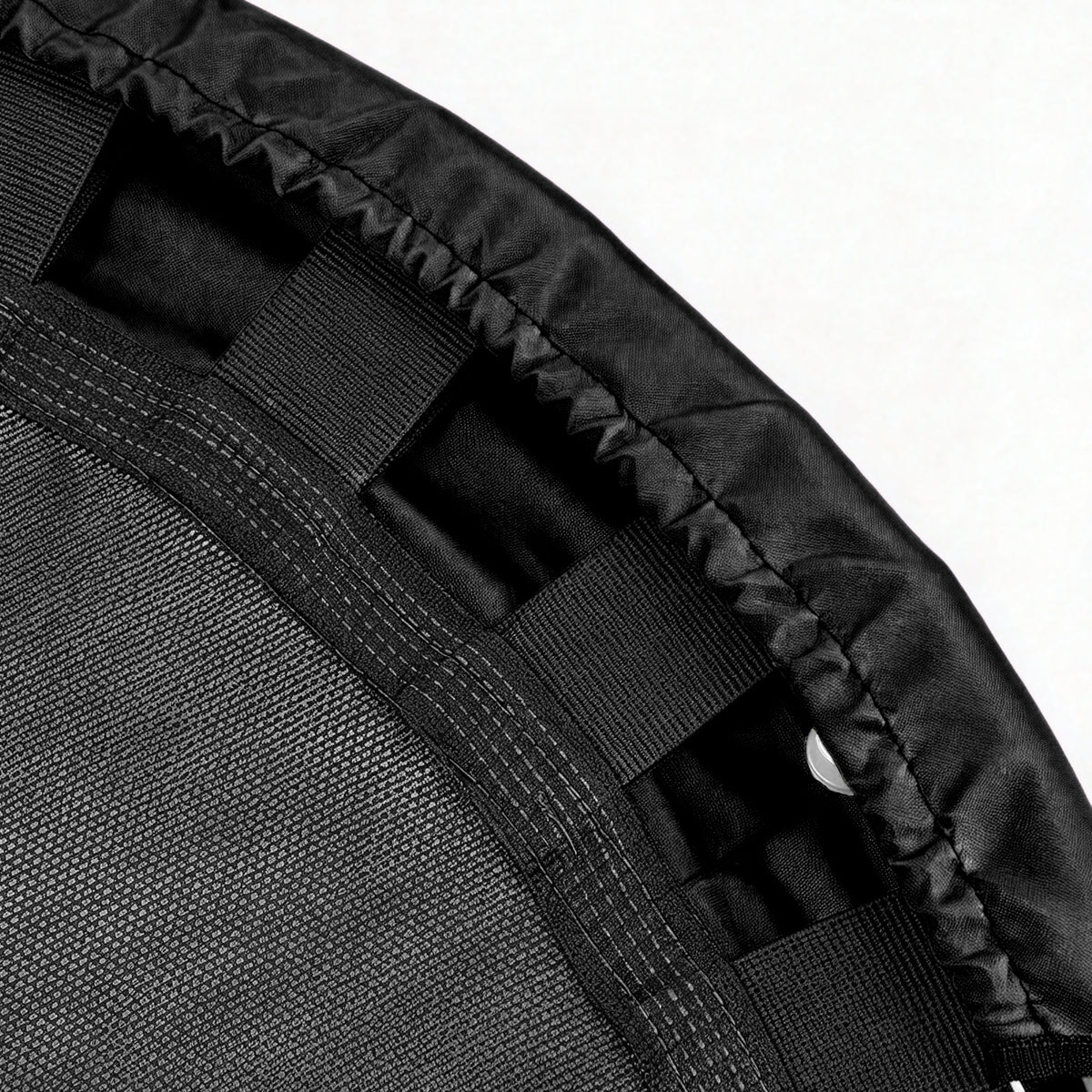 Close-up detail of a black trampoline or exercise mat showing the black mesh surface, padded edge, and webbing straps against a white background.